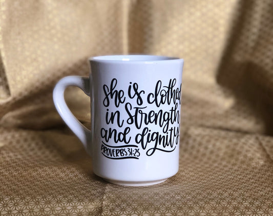 She is clothed....Enjoy your coffee in this 11 ounce ceramic coffee cup!